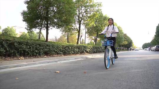 女孩在校园道路上骑自行车