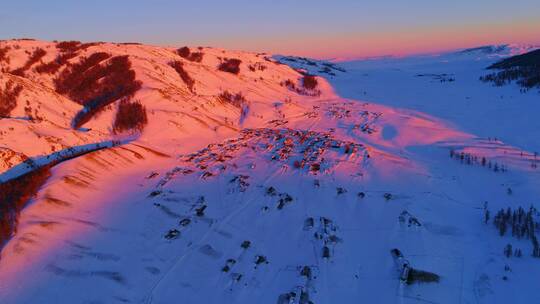 新疆阿勒泰雪山红色夕阳下的村落