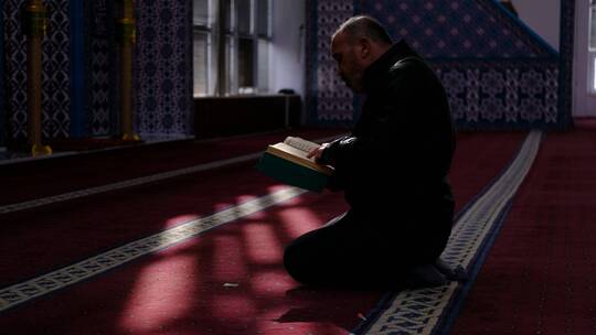 男子在清真寺阅读古兰经 