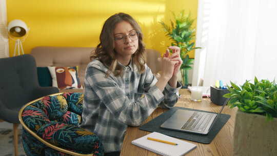戴着眼镜在笔记本电脑上工作的勤奋女学生坐