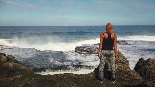 女性游客的慢动作是感觉自由，在岩石悬崖上