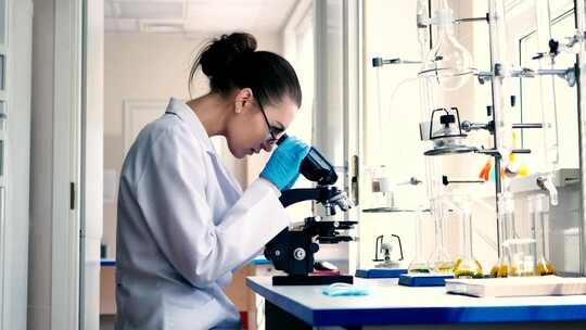 高清科技感科研实验室女人看显微镜视频