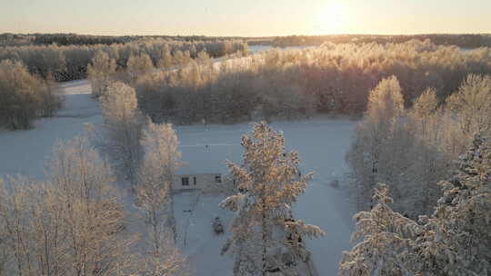 冬季森林雪树顶后面的田园诗般的北欧房子，
