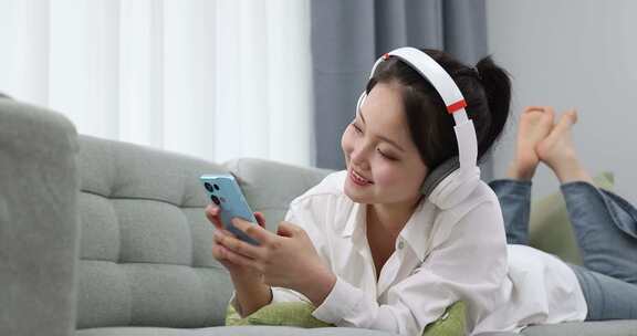 一位年轻女士在家戴着耳机听音乐