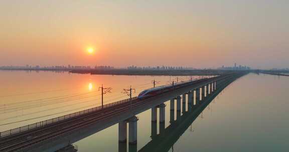 夕阳下高铁跨桥行驶景象