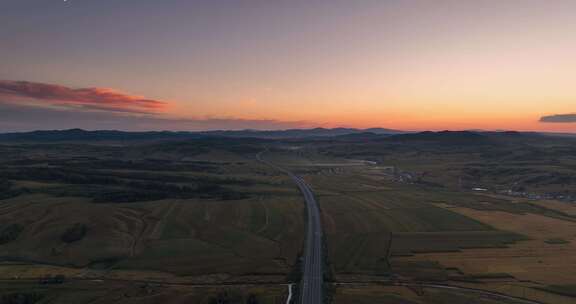 航拍夕阳下穿过草原的高速公路