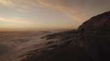 当海浪碰撞时，摄影师沿着海边的岩石行走高清在线视频素材下载