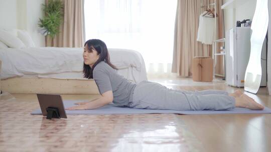 周末年轻都市白领在客厅瑜伽垫上做瑜伽视频素材模板下载