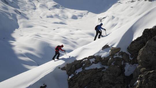 登山者在白雪覆盖的山上行走