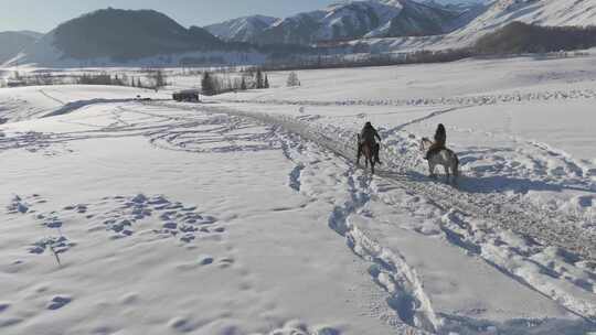 无人机冬日人在雪地骑马垂直fpv航拍跟随