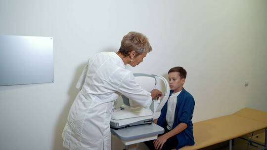 医生用仪器检查男孩的眼睛视频素材模板下载