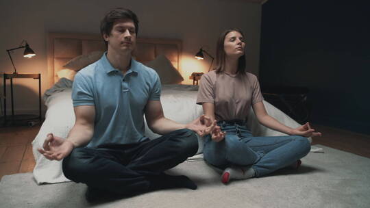 年轻夫妇坐在卧室打坐冥想视频素材模板下载