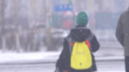 大雪天飘雪花妈妈带着孩子过马路走斑马线