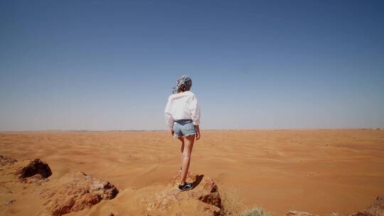 站在沙漠的沙堆上的女人