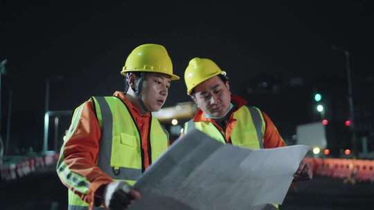 工地深夜工人看着图纸施工