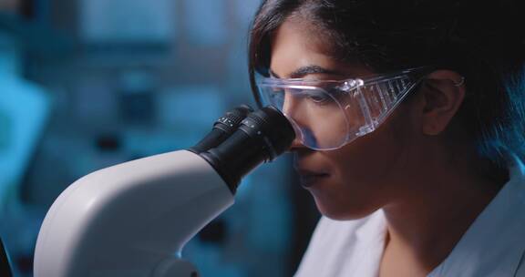 女科学家用显微镜观察病毒