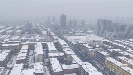 城镇飘雪楼房小区街道车流