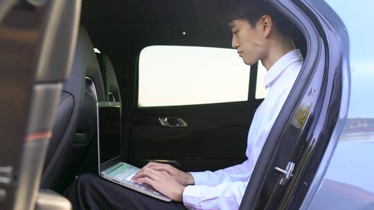 汽车内使用电脑办公的白衬衫商务男性
