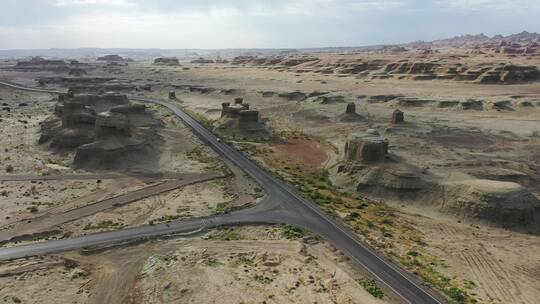 公路穿过新疆乌尔禾魔鬼城雅丹地貌群