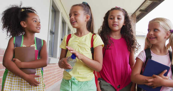 快乐的多样化女孩在学校走廊散步和交谈的视频