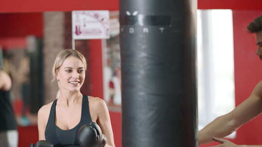 私人教练在体育俱乐部拳击锻炼中训练女性视频素材模板下载
