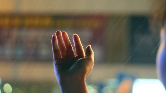 下雨天夜晚女孩坐车把手伸出窗外接雨滴视频