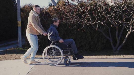 男人推残疾朋友跑步视频素材模板下载