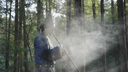 古代古装古人在烟雾缭绕的森林里吹洞箫