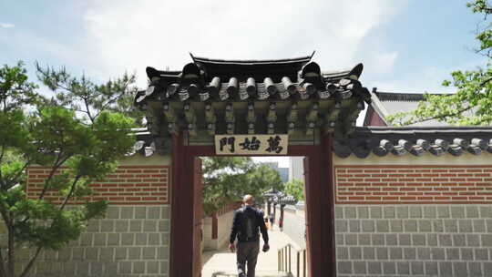 景福宫内有装饰屋顶和标志的大门，游客通过
