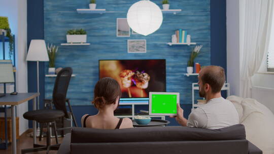 男人和女朋友拿着绿屏的触摸屏设备