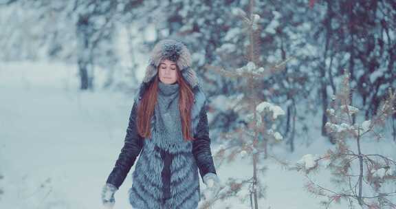 美丽的女人在雪地里行走