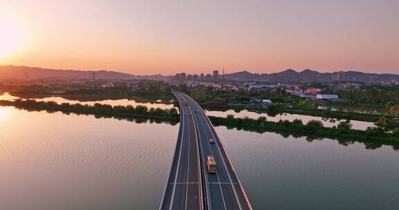 航拍夕阳下穿过鄱阳湖的乡间高速公路