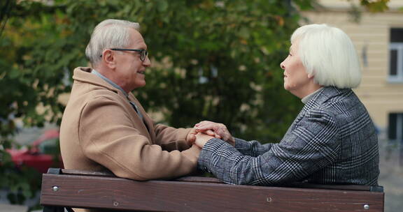 老年夫妻在公园长凳上聊天