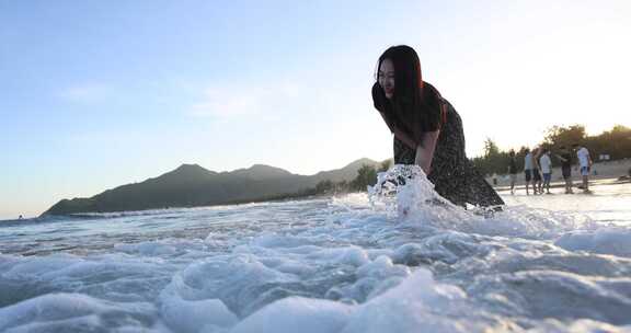 美女用手拍打浪花