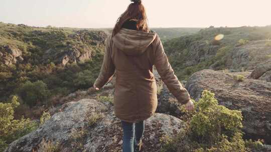 一个年轻的女旅行者在峡谷的山上散步