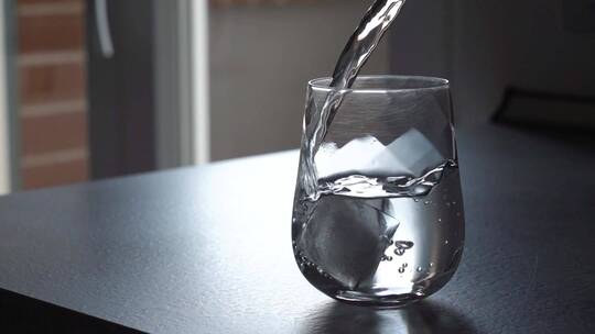 把水倒在装有冰块的杯子里