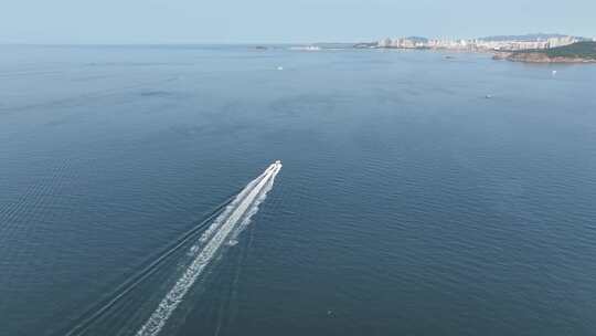 航拍跟随威海市高新区双岛湾海面上高速快艇