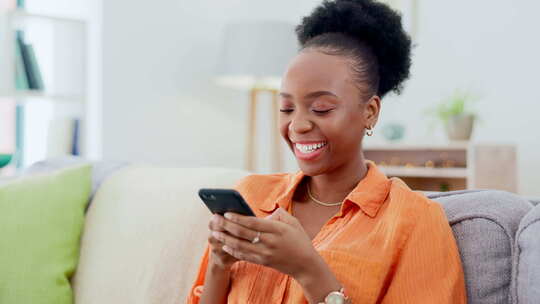 电话，快乐的黑人女人在沙发上打短信，同时