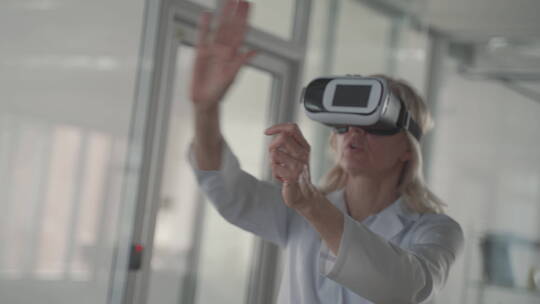 一位金发中年女医生用虚拟现实眼镜浏览数据视频素材模板下载
