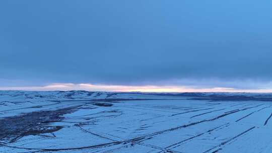 航拍浓郁夕阳下的垦区雪原