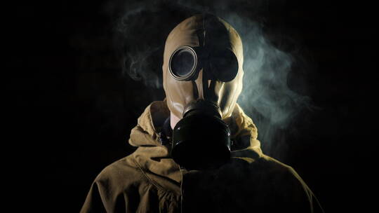 烟雾环绕着穿戴着防毒面具的男人