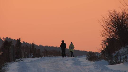 晨光中在雪地上行走的人4K