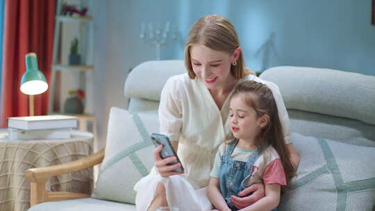 小孩和家长周末在沙发上玩手机视频素材模板下载