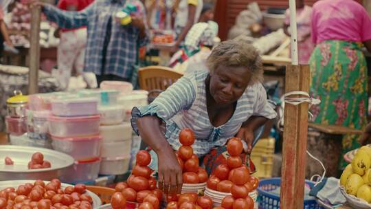 在集市里摆放西红柿的老板