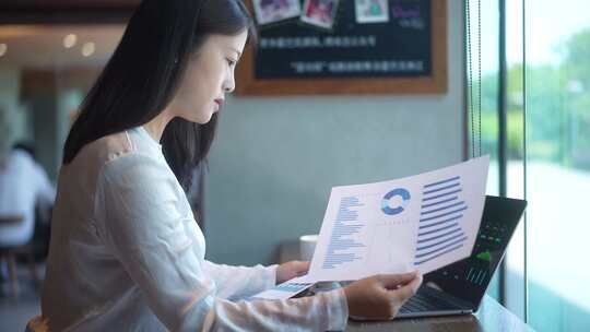 职业女性在笔记本电脑上看财务报表