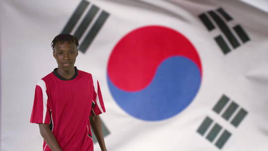 年轻足球运动员在韩国国旗前庆祝