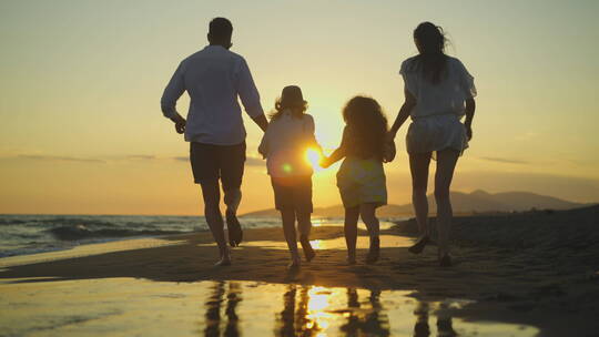 日落时分在海滩上全家欢奔