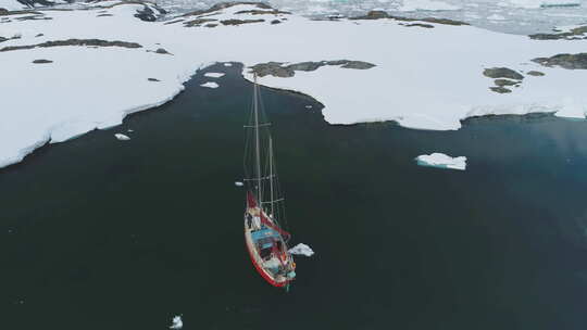 游艇航行在北极冰山海岸鸟瞰图