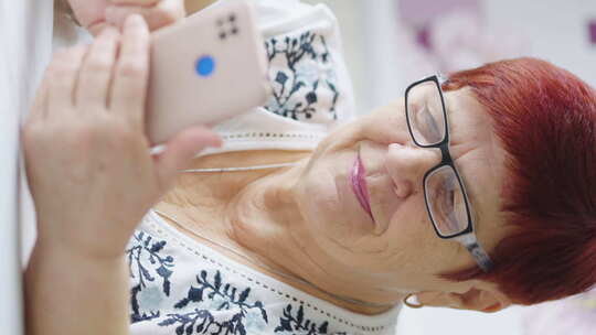 老年女性在沙发上玩手机