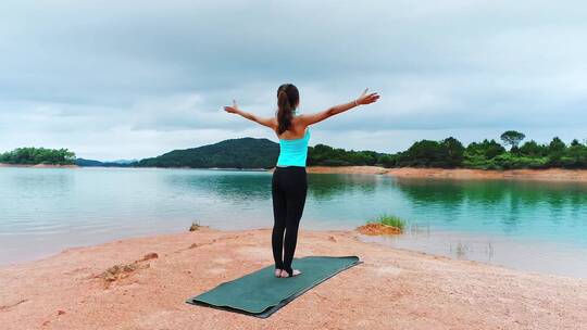 湖中练瑜伽的年轻女性